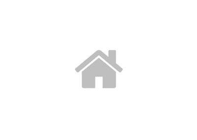 A simple grey house icon with a triangular roof and chimney against a white background.